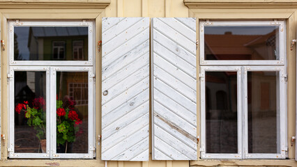 Historic old wood plank farm house two window with white shutters.