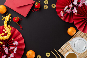Embracing the traditional chinese New Year tea ceremony. Top view flat lay of teapot, cup, tangerines, red envelope, gold dragon, traditional chinese elements on black background with promo zone