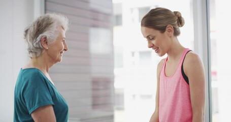 Elderly, woman and coach with dumbbell for workout, exercise or fitness with communication and instructions. Senior, person and personal trainer with weight lifting, training and conversation at gym