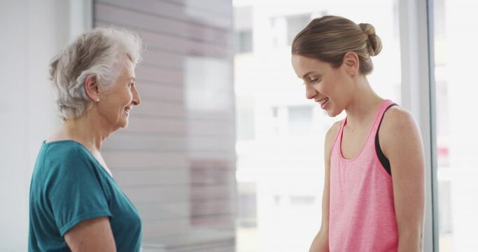 Elderly, woman and coach with dumbbell for workout, exercise or fitness with communication and instructions. Senior, person and personal trainer with weight lifting, training and conversation at gym