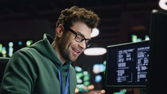 Smiling analyst typing keyboard desktop computer in data center room closeup
