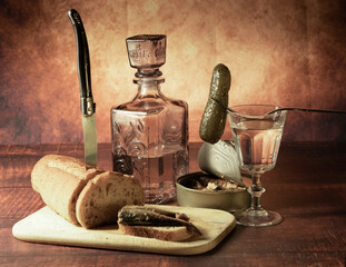 Antique-style still life with alcohol, vodka, canned fish, bread and cucumber. - 701962837
