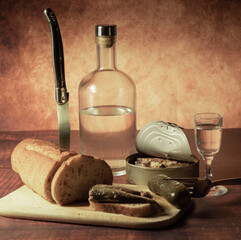 Antique-style still life with alcohol, vodka, canned fish, bread and cucumber. - 701962851