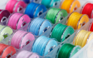 Plastic bobbins for a sewing machine with multi-colored threads.