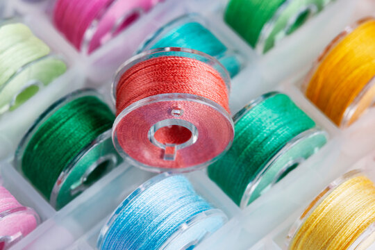 Plastic bobbins for a sewing machine with multi-colored threads.