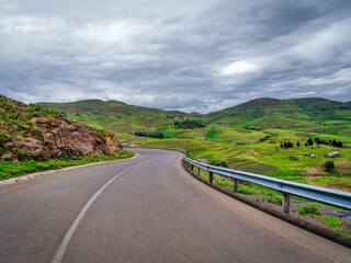 Winding road A5 through traditional Lesotho villages with rolling hills and mountains