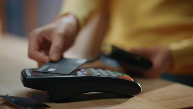 Closeup woman hands paying credit card over terminal at store. Client payment
