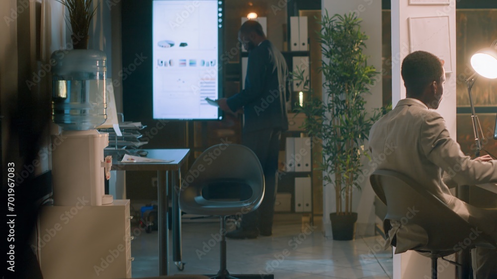 Aufkleber employee enjoying cup of coffee while checking statistical graphs on computer during nightshift, hel