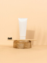 White plastic toothpaste tube and wooden toothbrush