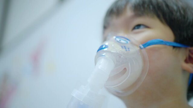 A little boy having a medicine inhalation with a nebulizer mask in the hospital.