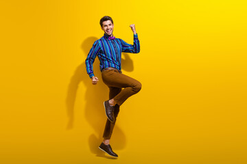 Fototapeta na wymiar Full body photo of satisfied optimistic man wear bow tie stylish shirt clenching fists win lottery isolated on yellow color background