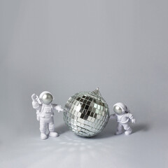 Two astronauts around a disco ball. Party concept. Square banner. Selective focus, copy space