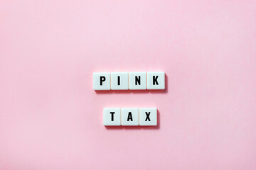 Words Pink Tax from plastic blocks on pastel background. Selective focus, copy space