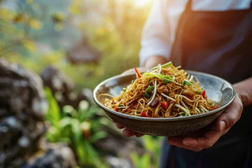 Schilderijen op glas Gastronomic Journey: Chef Holding a Plate of Chinese Delicious Chow Mein with the Majestic Great Wall of China in the Background - A Fusion of Culinary and Cultural Delight © Mr. Bolota