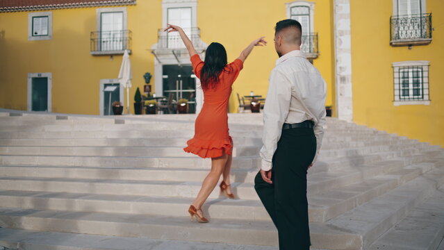 Passionate hispanic couple dancing hot choreography latin style on street stairs