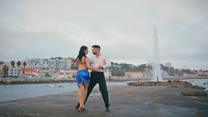 Passionate pair performing latin american dance on embanking. Couple dancing 