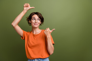 Photo of young businesswoman pointing fingers empty space looking interested proposition join our team isolated on khaki color background