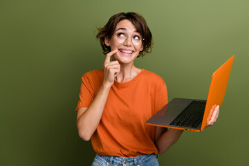 Photo of dreamy young lady holding modern computer and thinking how she working remote look empty...