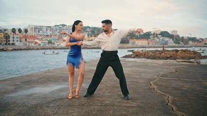 Couple dancing tango coast cloudy day. Hot performers practicing latino dance.