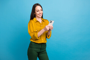 Photo of confident pretty lady wear yellow shirt communicating modern device empty space isolated blue color background