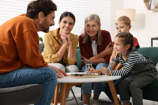 Family playing checkers at coffee table in room