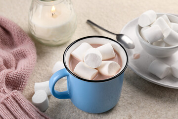 Cup of aromatic hot chocolate with marshmallows served on beige table, closeup