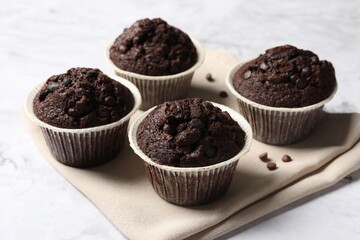Tasty chocolate muffins on white table, closeup