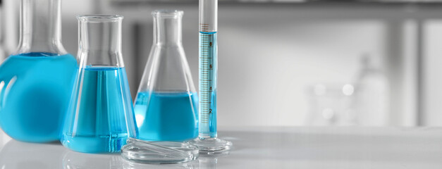 Laboratory analysis. Different glassware with liquid samples on table, space for text. Banner design