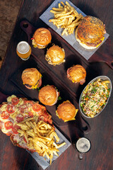 Homemade fresh meat burgers with potato bread with egg bacon tomato lettuce onion cheddar cheese ham dressings different varieties with fries fast food