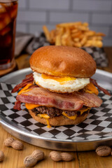 Homemade fresh meat burgers with potato bread with egg bacon tomato lettuce onion cheddar cheese ham dressings different varieties with fries fast food