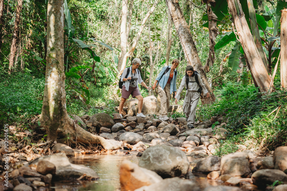 Wall mural young female backpacker group traveling in wild forest, attractive girl traveler look around and exp