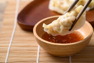 Steamed wonton dumpling stuffed with minced pork and chicken eating with sesame oil sauce