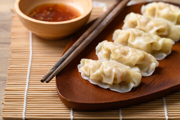 Steamed wonton dumpling stuffed with minced pork and chicken eating with sesame oil sauce