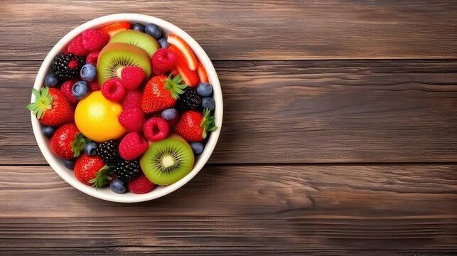 Fresh berries in a bowl on wooden table. Top view with copy space