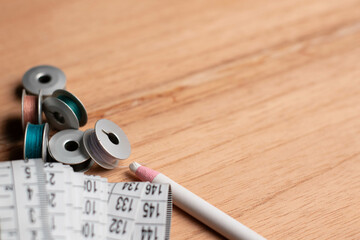 thread spools and tape measure on wooden table