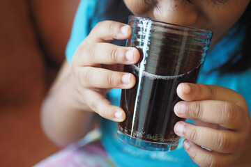 child drinking glass of soft drinks