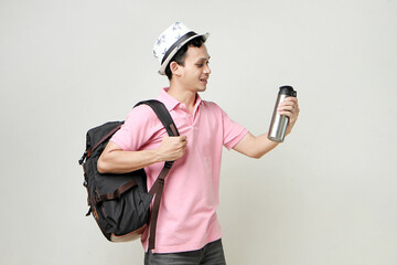 Asian man backpacker hold tumbler bottle. travelling concept. on isolated background