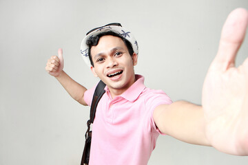 Asian man backpacker taking selfie photos. digital nomad and travelling concept. on isolated background