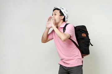 Asian man backpacker shouting outloud. digital nomad and travelling concept. on isolated background