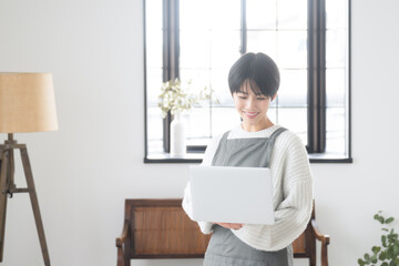 部屋でパソコンを使い、売上などを考えるのショップの販売員や接客業のような女性