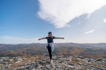 Obraz premium woman backpack on mountain peak looking in beautiful mountain valley in autumn. Landscape with sporty young woman, blu sky in fall. Hiking. Nature