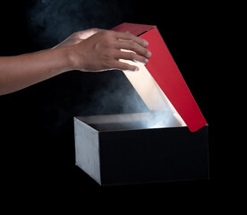 hand hold and open a mysterious box, smoke float up from box over dark background - 702025608