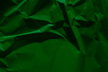 Green old crumpled paper texture in low light background,wrinkled paper