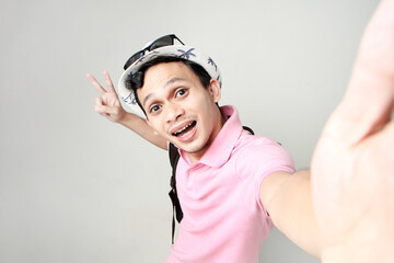 Asian man backpacker taking selfie photos. digital nomad and travelling concept. on isolated background