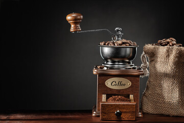 Classic Vintage Coffee Mill And Jute Bag With Beans On Dark Background.