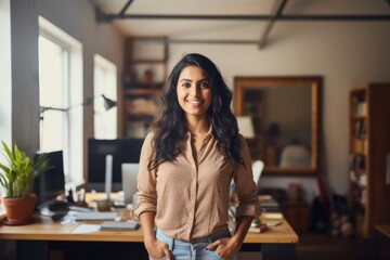 smiling businesswoman with crossed arms looking at camera at workplace in office, Cheerful indian girl standing at home office looking at camera, AI Generated - obrazy, fototapety, plakaty
