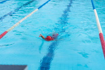 child swimmer swim in swimming pool. Water sports and competition, learning to swim classes for...