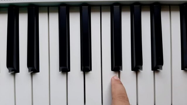 A beginner tries to play a note on the piano