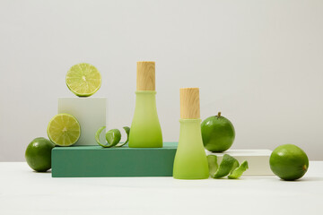 Two jars of homemade cosmetics and fresh lemons are displayed on platforms. The white background...