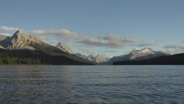 Calm Maligne Lake with distant mountain peaks from Canadian Rockies